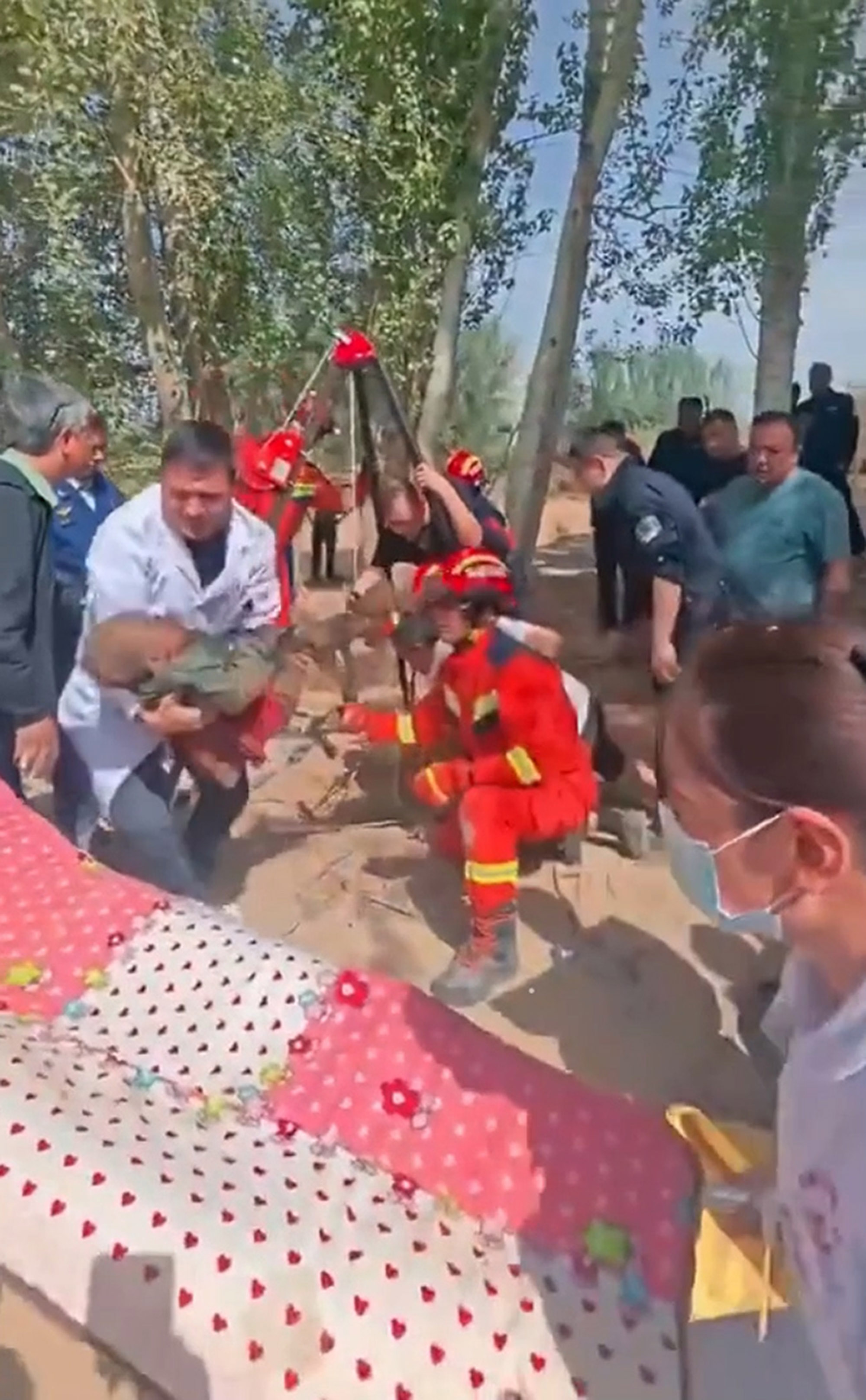 Female officer rescues a child trapped in a well in Hotan, Xinjiang, China, on Apr.16, 2025. The child was saved. Note: Photo is a screenshot from a video. Female officer rescues a child