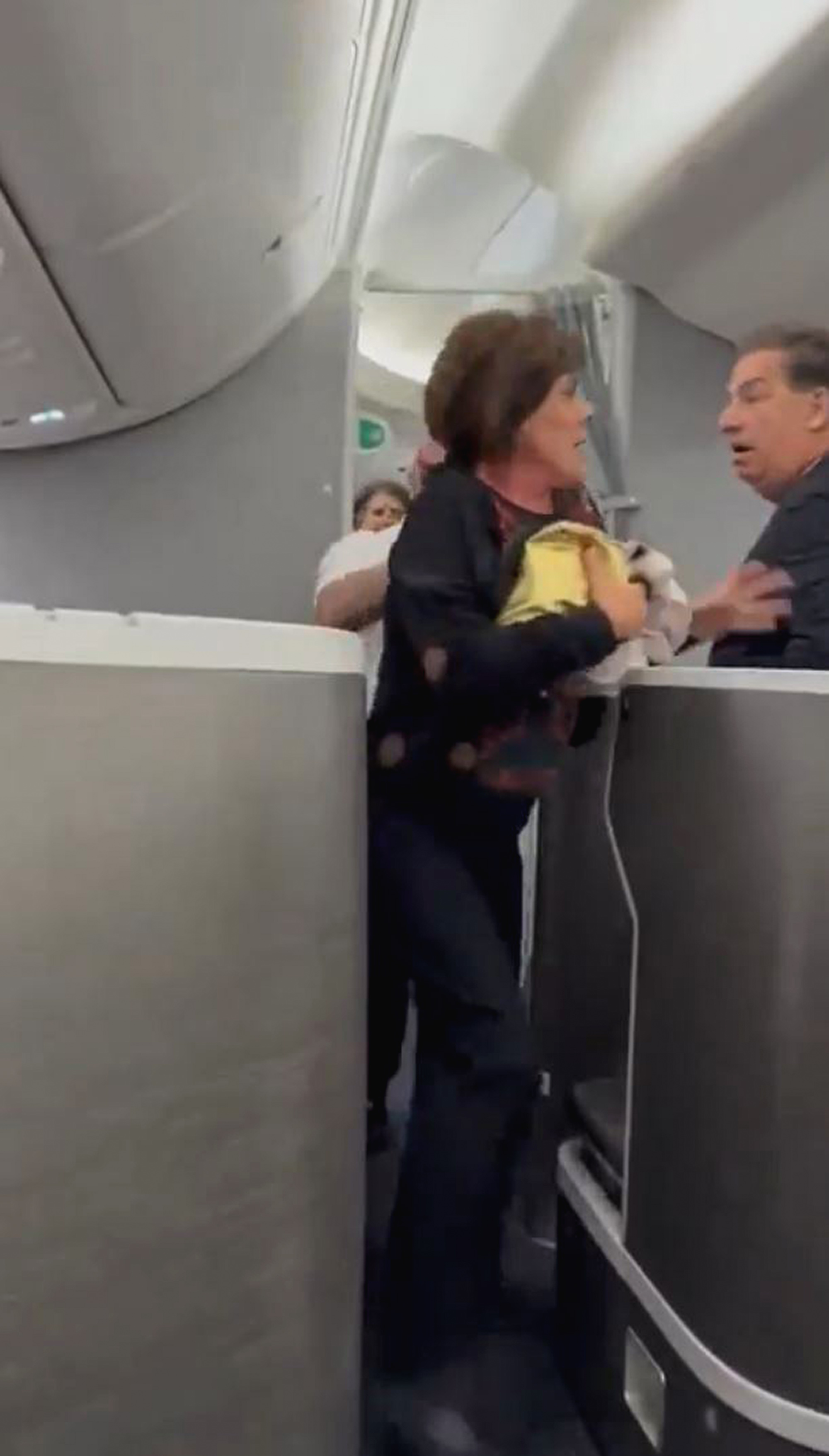 Flight attendants restrain Brazilian woman after attempting to enter the cockpit to question delay in Sao Paulo, Brazil, April 24, 2025. The flight was bound for New York. Note: Photo is a screenshot from a video Flight attendants restrain Brazilian woman