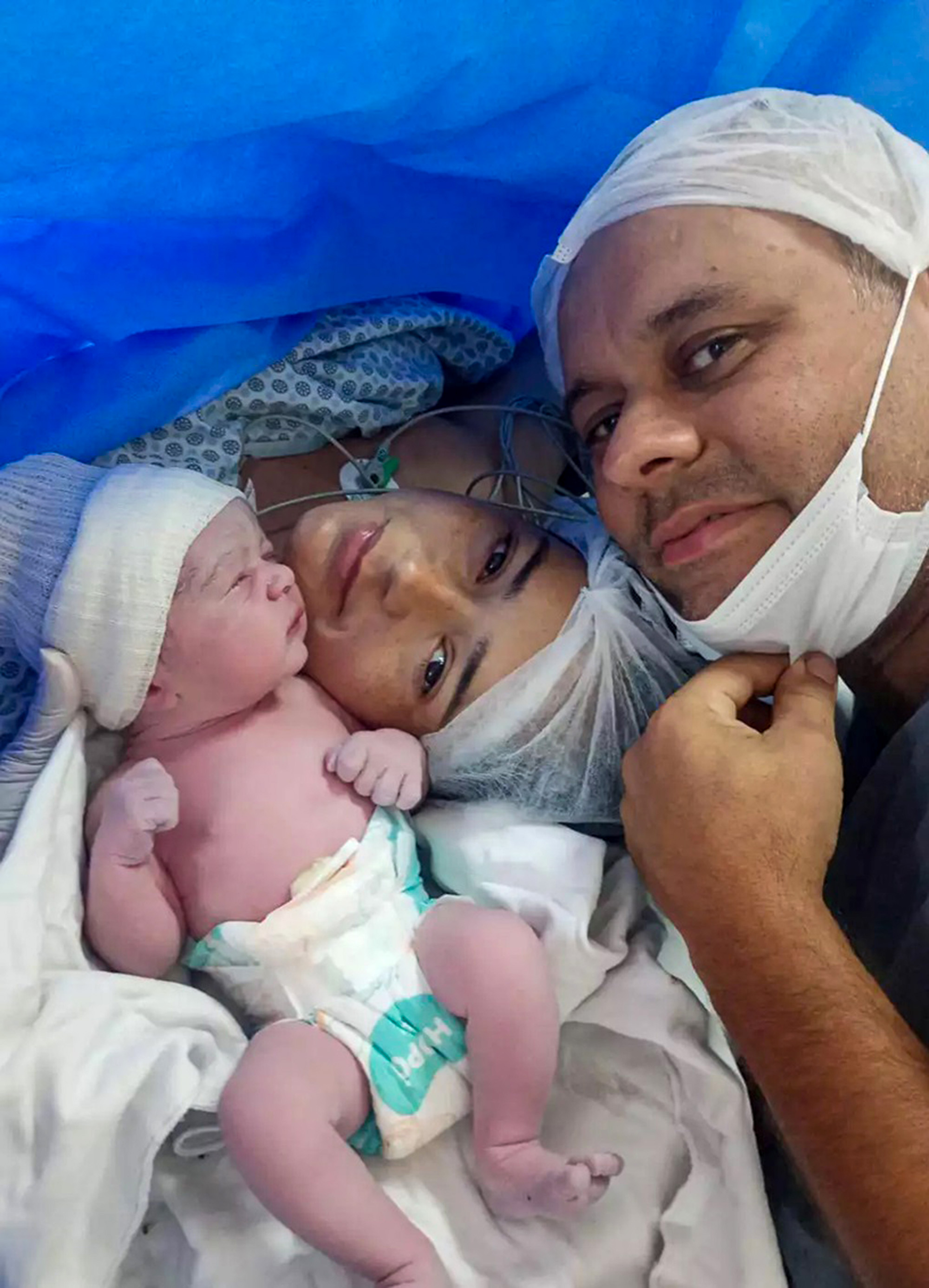 Amanda Porfirio da Silva, 33, her husband Thiago Jusis with their newborn