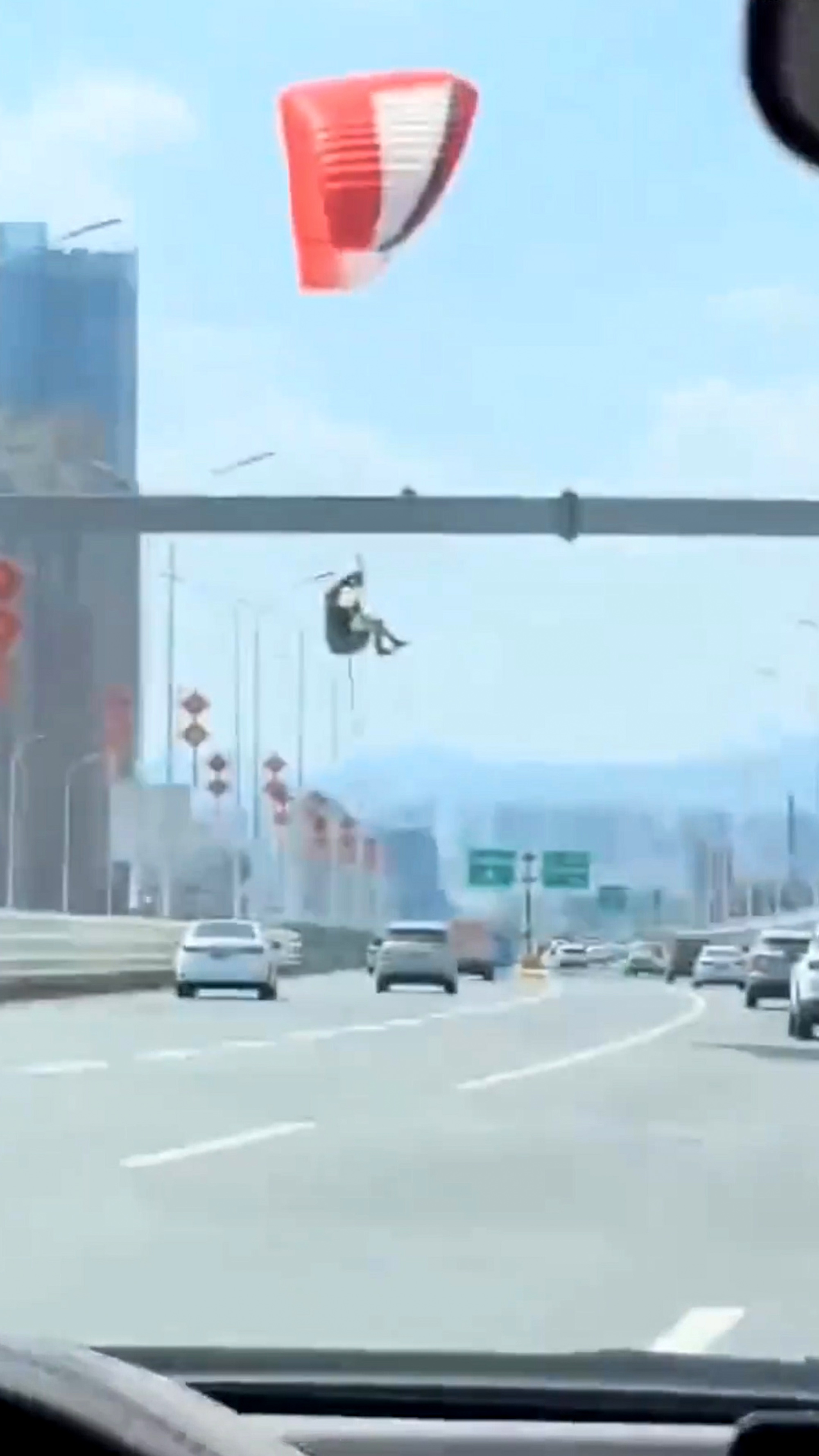 Woman paragliding lands on busy expressway in Nanchang, Jiangxi Province, China, on 25 April, 2025. She managed to land without incident. Note: Photo is a screenshot from a video. Woman paragliding lands on busy expressway