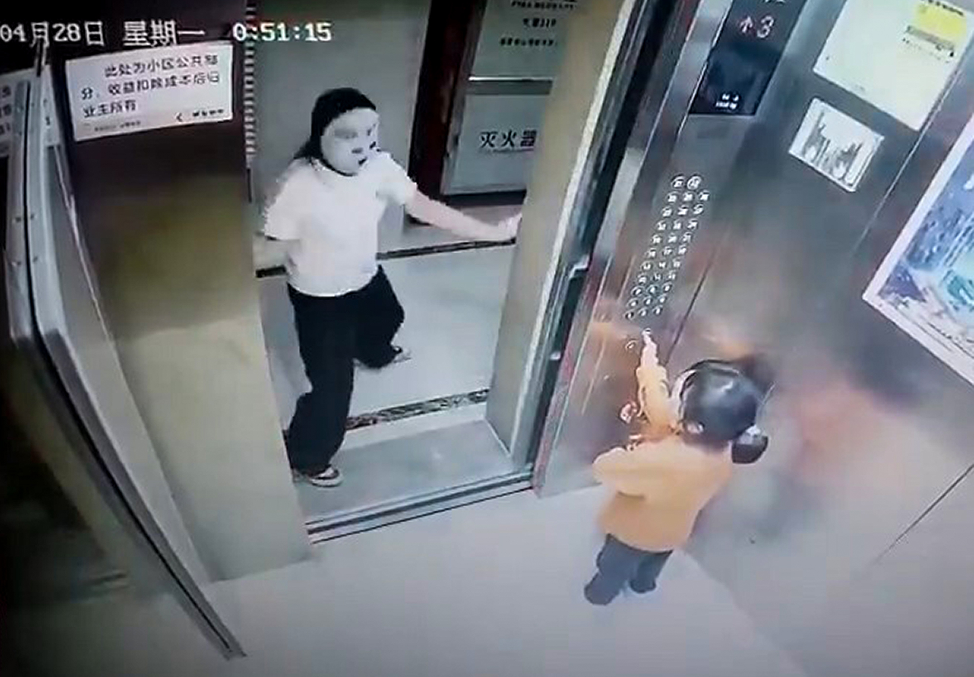 Masked woman scares two girls in elevator in Xinluo District, China, April 28, 2025. She prevented them from closing the elevator door. Note: Photo is a screenshot from a video. Masked woman scares two girls