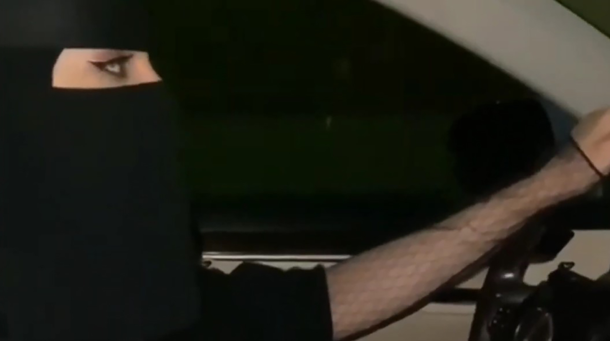 Illustrative image shows woman with veil on driving a car, undated. Note: Image is a screenshot from video. Illustrative image shows woman with veil on driving a car