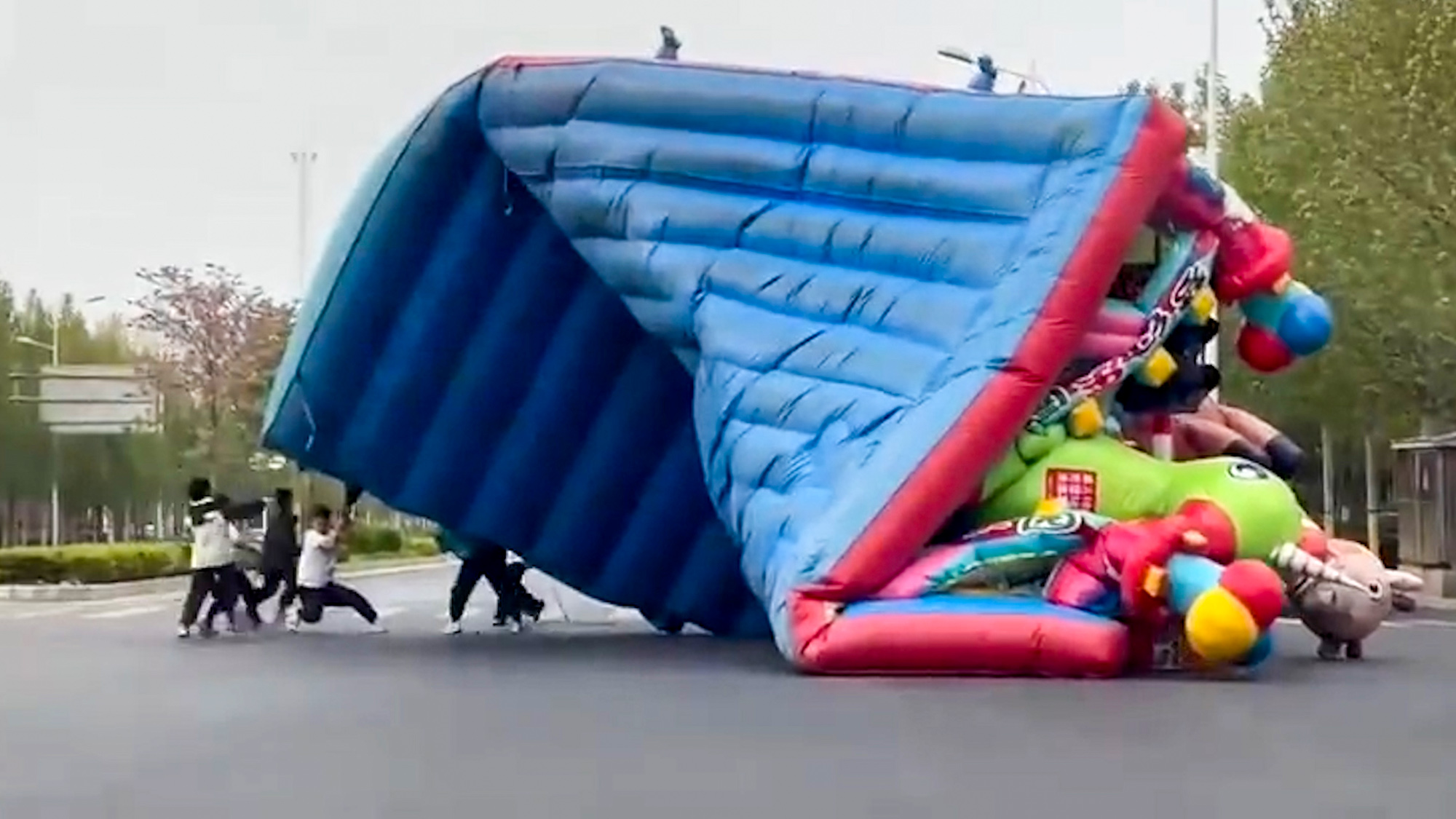 Video shows a man carrying a bouncy castle in Zhengzhou, Henan, China, on Apr.04, 2025. It was blown away from an amusement park. Video shows a man carrying a bouncy castle in Zhengzhou, Henan, China.